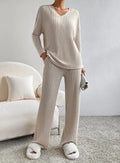 Casual 2-Piece Loungewear Set in beige ribbed fabric, featuring a V-neck top and matching wide-leg pants, styled with plush slippers.