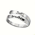 Heart-shaped stainless steel spiral ring engraved with "Just breathe" and a small heart, showcasing a minimalist design.