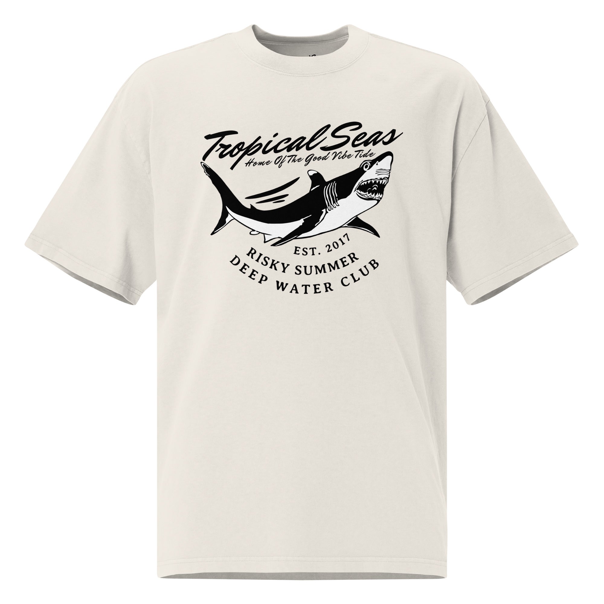 Oversized faded t-shirt in light beige featuring a shark graphic and "Tropical Seas" text, with a loose fit and wide neck.