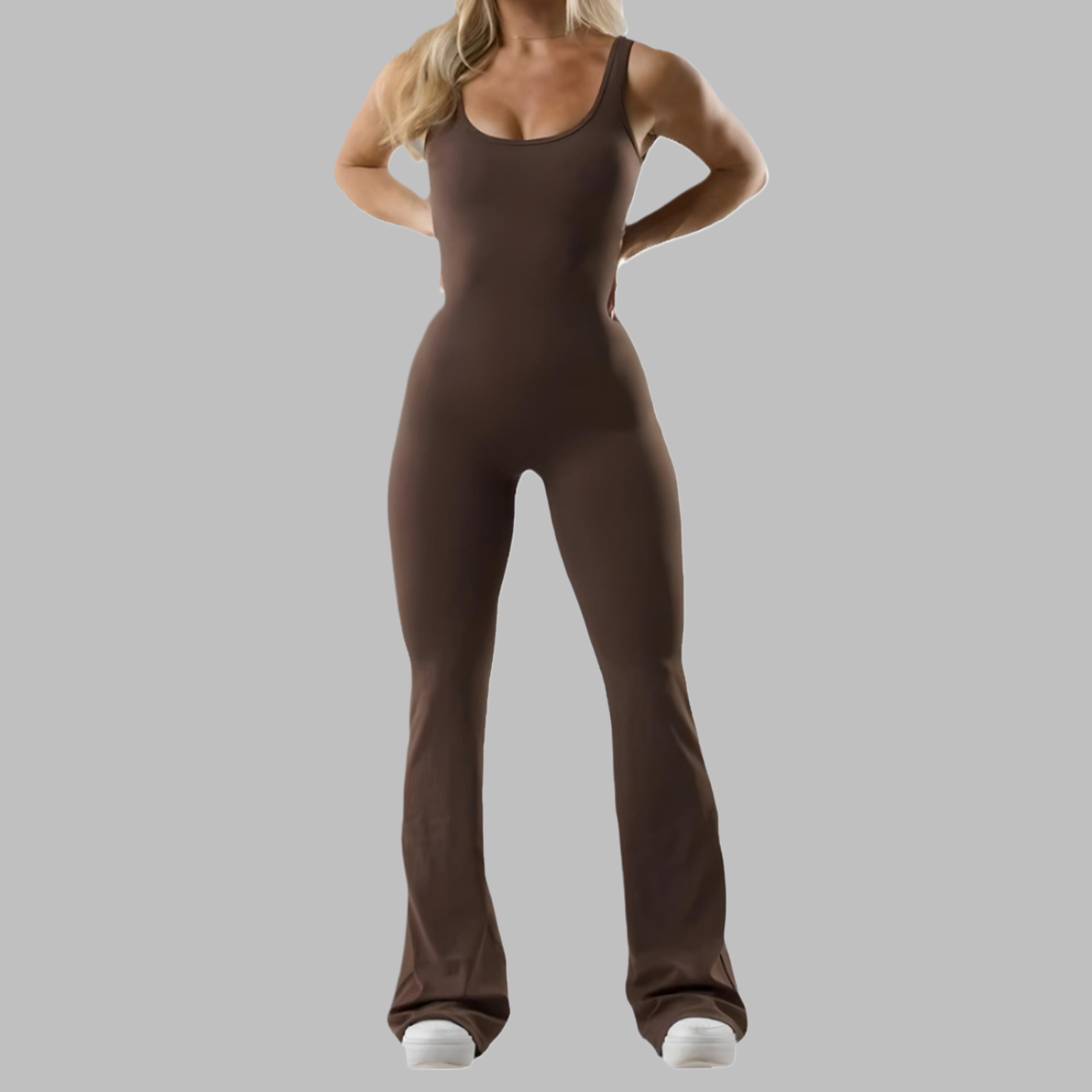 Flared jumpsuit in a rich brown hue, featuring a fitted bodice and flared legs, worn with white sneakers.