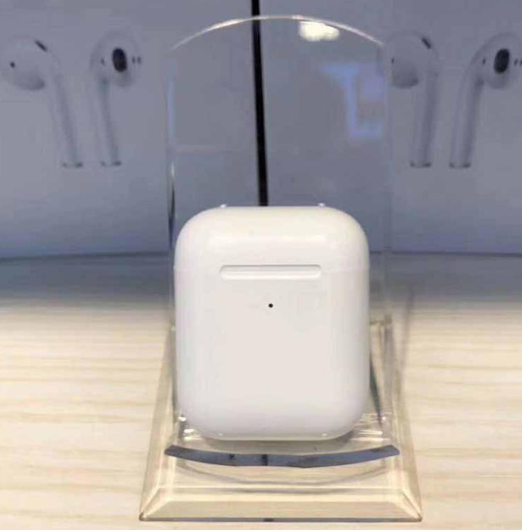 White i80 TWS Bluetooth earbuds in a charging case, displayed on a clear stand, with earbuds in the background.