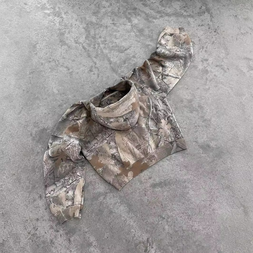 Oversized urban camo hoodie in shades of beige and gray, featuring a high collar, loose fit, and long sleeves.