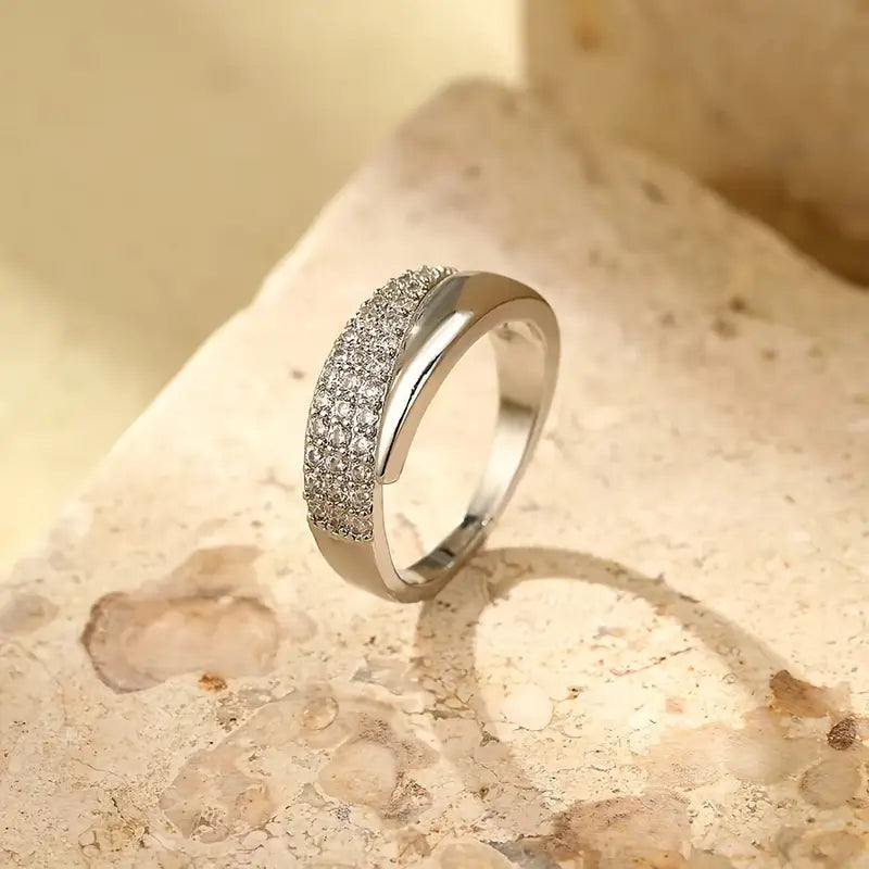 Elegant Adjustable Sparkle Ring with multiple rows of shiny stones, featuring a stylish silver band on a textured surface.
