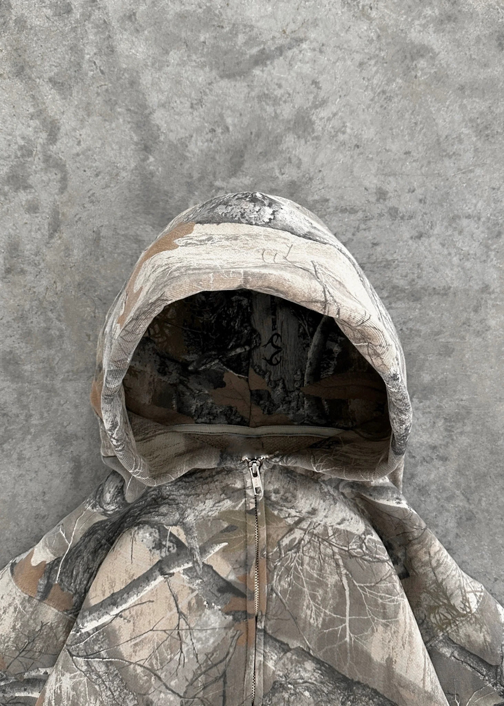 Unisex oversized hoodie in camouflage print, featuring a zip front and adjustable hood for a relaxed streetwear style.