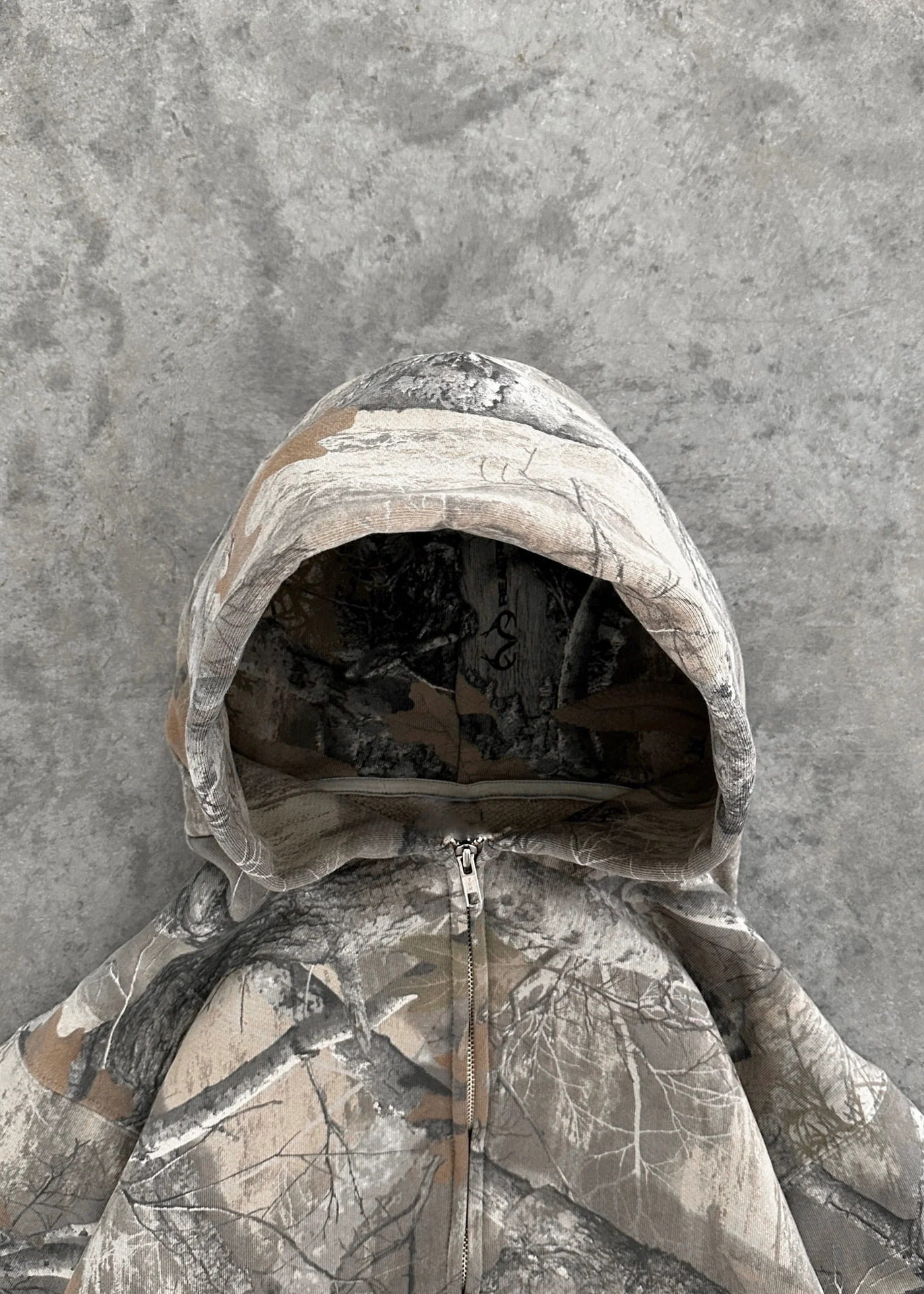 Unisex oversized hoodie in camouflage print, featuring a zip front and adjustable hood for a relaxed streetwear style.