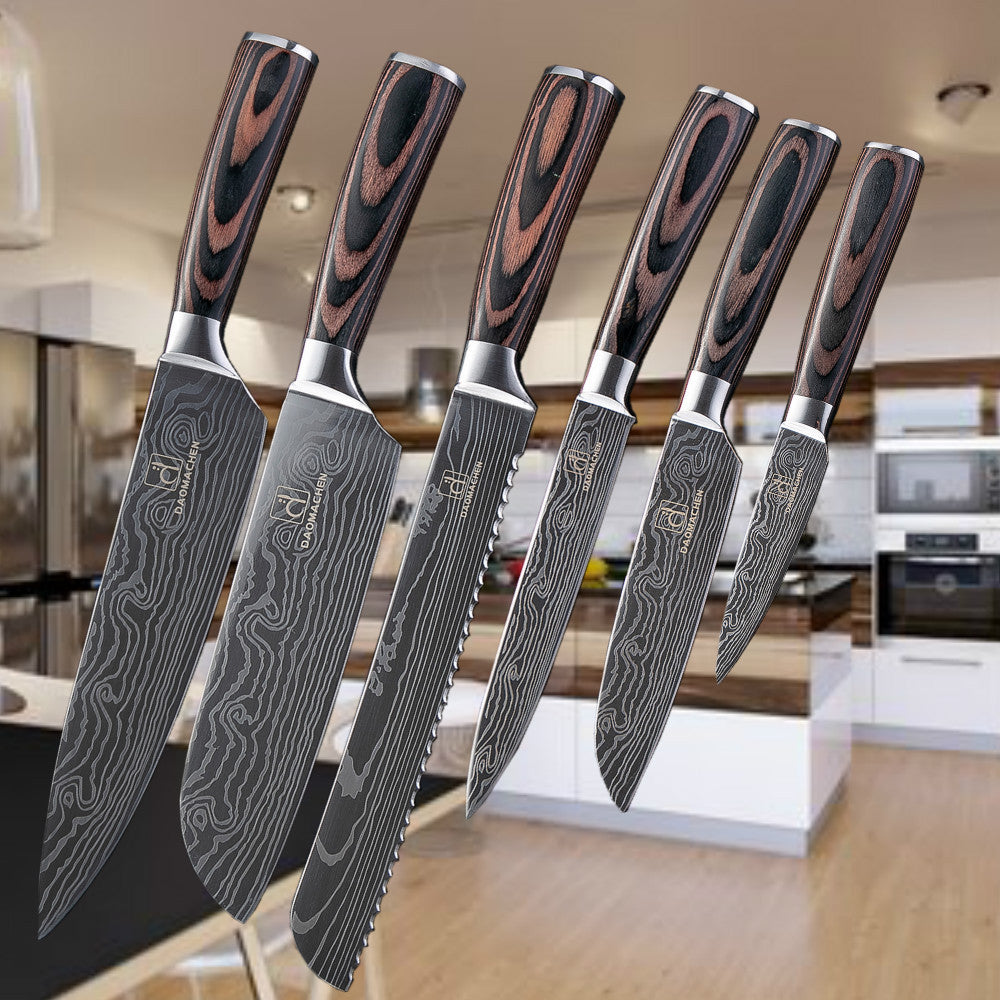 Five Damascus style kitchen knives arranged on a countertop, featuring patterned black and gray blades and wooden handles.