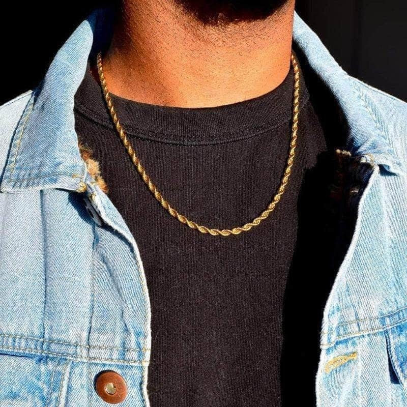 Gold twisted rope Figaro necklace worn over a black shirt, paired with a denim jacket showcasing its stylish design.