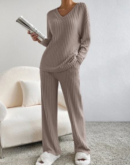 Casual 2-Piece Loungewear Set in a soft beige ribbed fabric featuring a V-neck top and matching pants, styled with cozy slippers.