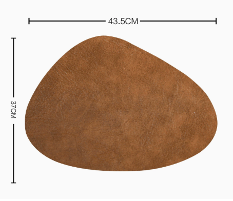 Waterproof leather placemat in a warm brown color, featuring a smooth texture and irregular shape with rounded edges.