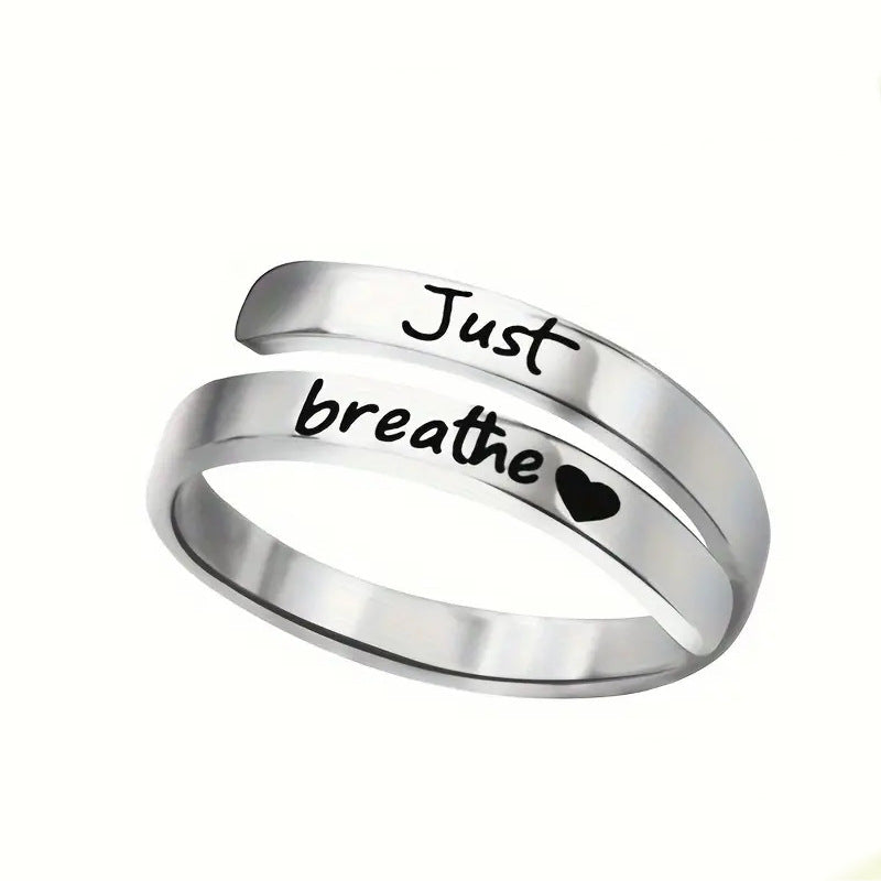 Silver spiral ring with "Just Breathe" engraving, heart shape, made of durable stainless steel. A stylish reminder of peace.