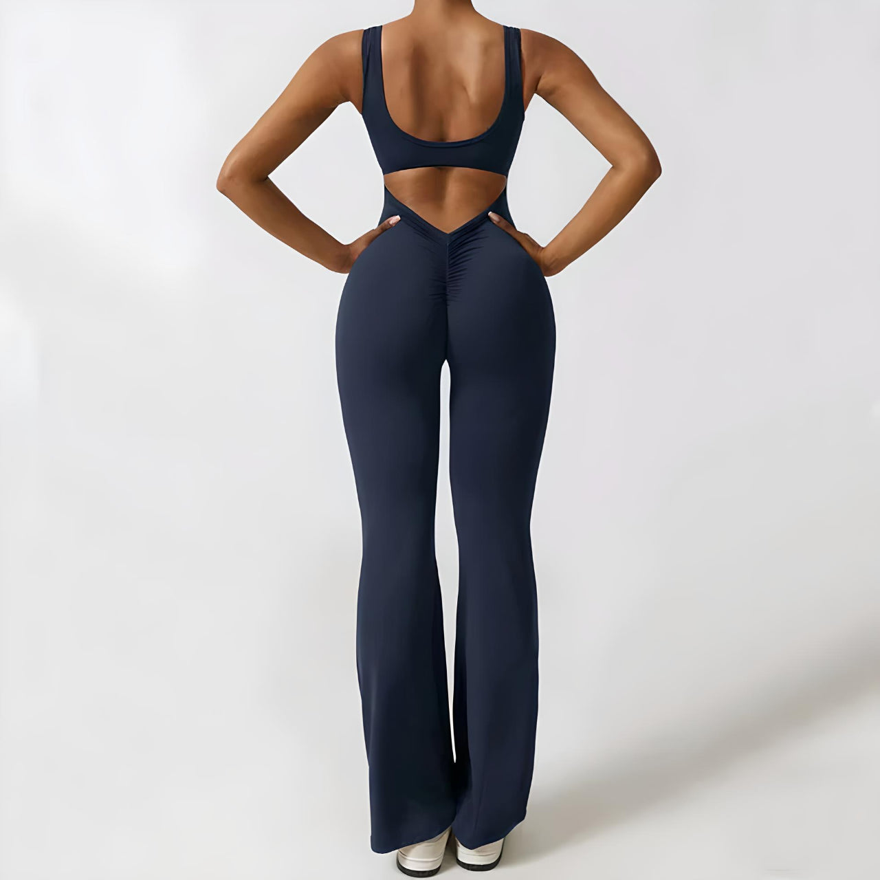 Navy flared jumpsuit featuring a fitted bodice and cut-out back, styled with adjustable straps for a customized fit.